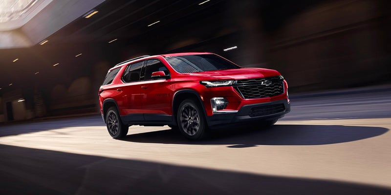 Red 2023 Chevy Traverse driving down road
