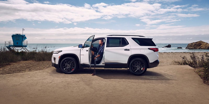 Side view of a white 2023 Chevy Traverse parked at the beach